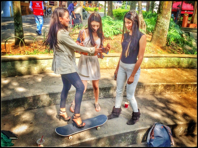 Three cute Colombian girls trying out my skateboard.